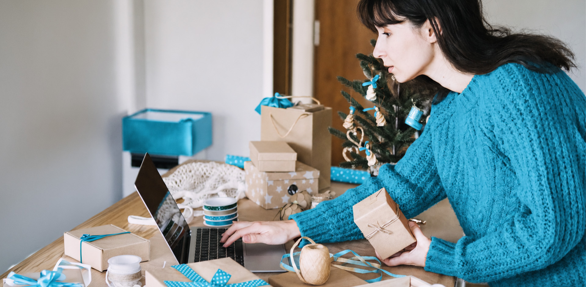 Woman at home shipping station packaging orders for holidays